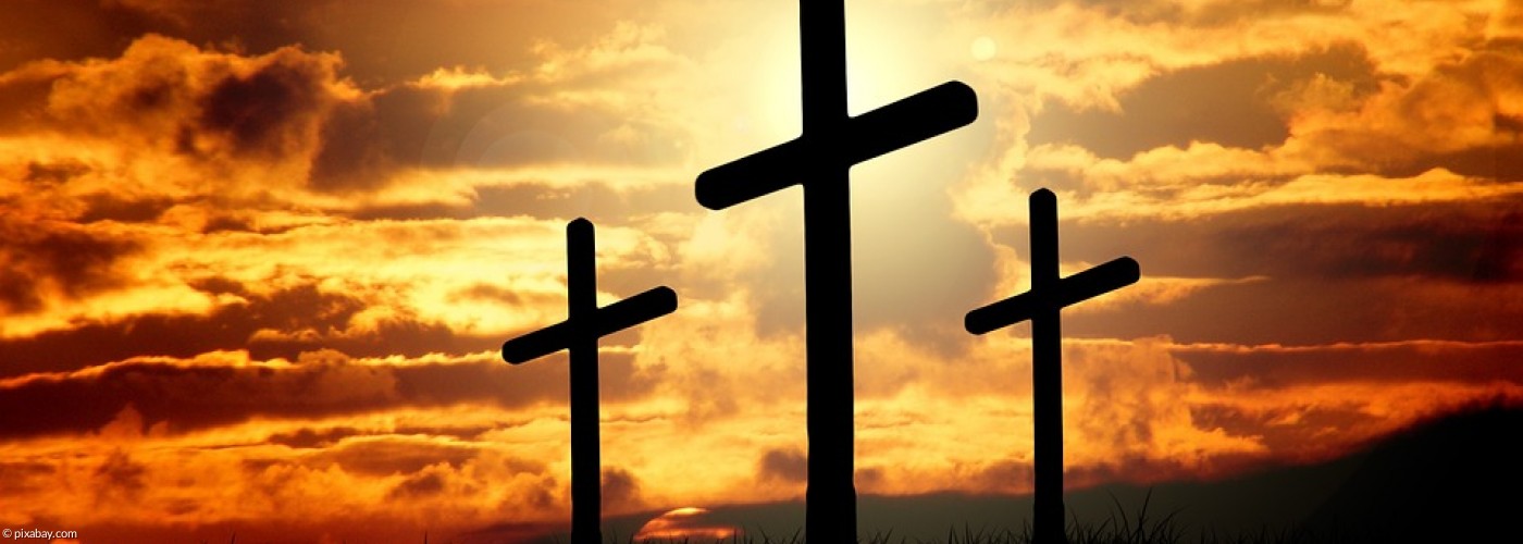 drei Kreuze, im Hintergrund ein Sonnenaufgang