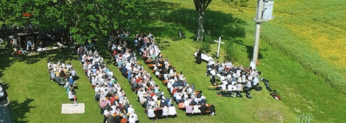 Luftbild von oben, Gottesdienst auf der Wiese, Altar, Bänke