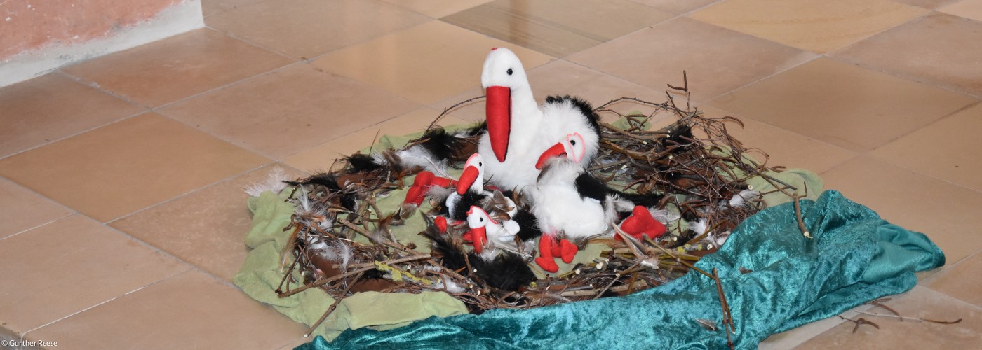 Storch aus plüsch in einem gebastelten Nest