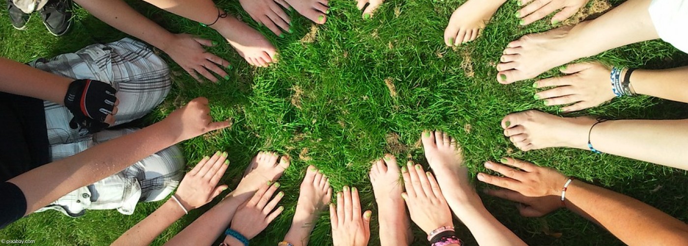 Hände und Füße von Kindern in einem Kreis