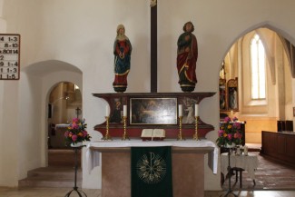 Altar mit Altarbild, Bibel und Sakristei im Hintergrund