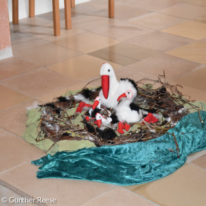 Storch aus plüsch in einem gebastelten Nest