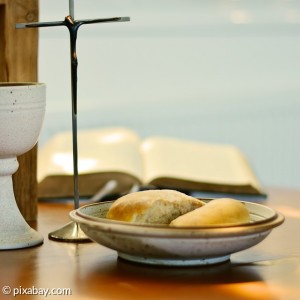 Weinkelch, Teller mit Brot, Kreuz und Bibel 